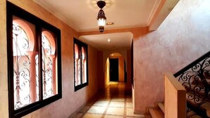 A hallway with patterned windows, a tiled floor, and a staircase with ornate railings. - Residence La Kasbah de Marrakech 4640 (Marrakech)