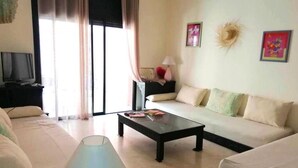 A living room with a sofa, a coffee table, a TV, and a lamp. - Residence La Kasbah de Marrakech 4640 (Marrakech)