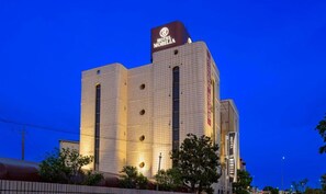 A hotel with a prominent sign, multiple windows, and a tiled facade.