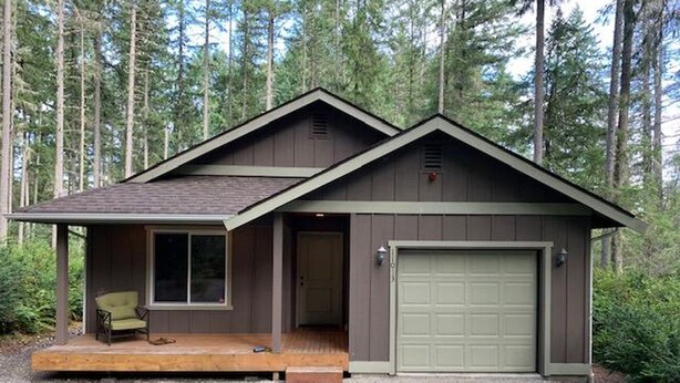 A small, single-story cabin with a porch and a garage, surrounded by a forest. - Anderson Island's most peaceful home (Anderson Island)