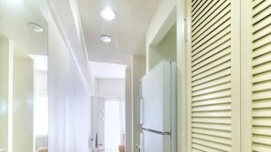 A hallway with a white door, a light-colored wall, and a ceiling with recessed lighting. - Pia Resort Hotel Corner Studio Room 3 (Tamuning)