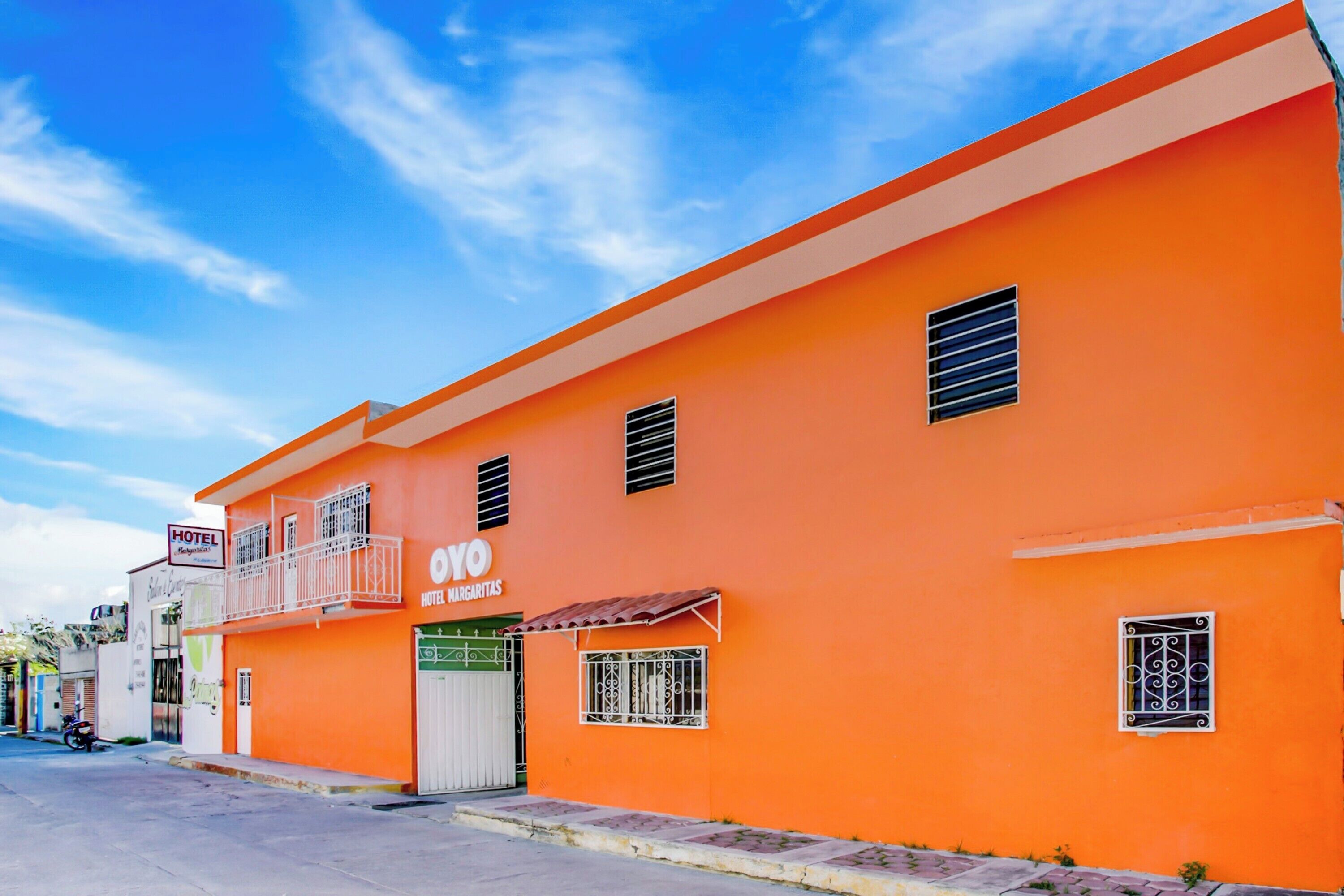 Un edificio de dos pisos con un letrero que indica que es un hotel llamado "OYO Hotel Margarita".