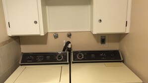 A laundry room with two front-loading washing machines and a cabinet above them. - great for kids - pets welcome - self check in - downtown - kitchen and laundry (Idaho Falls)