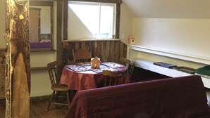 A cozy room with a wooden table, a chair, a small wooden cabinet, and a window with curtains. - great for kids - pets welcome - self check in - downtown - kitchen and laundry (Idaho Falls)
