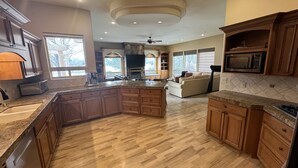 A spacious kitchen with wooden cabinets, granite countertops, and a large island. - Walla Walla Wine Country Estate (Walla Walla)