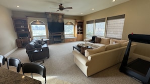 A spacious living room with a fireplace, seating area, and large windows. - Walla Walla Wine Country Estate (Walla Walla)