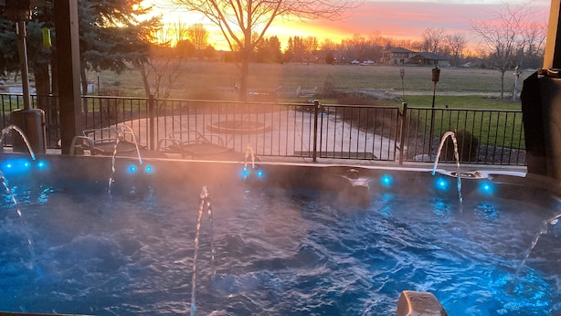 A hot tub with multiple jets, set against a sunset view. - Walla Walla Wine Country Estate (Walla Walla)