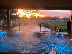 Un jacuzzi con múltiples chorros, frente a una vista de atardecer.