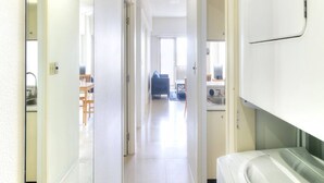 A bright, modern kitchen with white cabinets, a large white refrigerator, and a built-in oven. - Pia Resort Hotel Standard 2 Bedroom 2 (Tamuning)