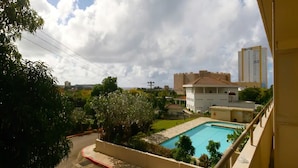 A residential area with a swimming pool, a large building, and a clear sky. - Pia Resort Hotel Standard Studio 2 (Tamuning)