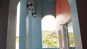 A balcony with a view of a green landscape, a small table, and two chairs. - Kenting Wonderful Hotel (Hengchun)