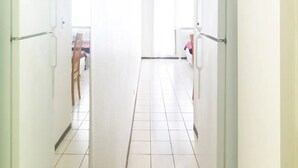 Eine helle, moderne Küche mit weißen Schränken und Fliesenboden.