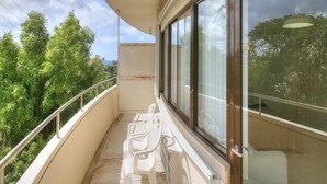 A balcony with a view of greenery and a cloudy sky. - Pia Resort Hotel Corner Studio Room 1 (Tamuning)