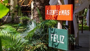 Un letrero con la inscripción 'PORTO DO MAR' y 'AGENTE E MAIS', y un letrero que dice 'FELIZ' debajo.