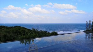 A clear view of a pool with a glass bottom, surrounded by greenery and overlooking the sea. - Twilight BnB (New Taipei City)
