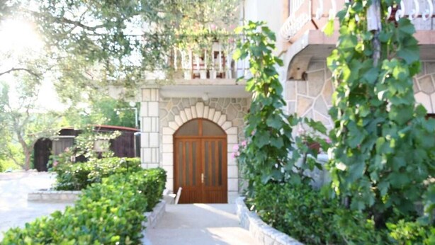 A building with a stone facade, a wooden door, and a small balcony.