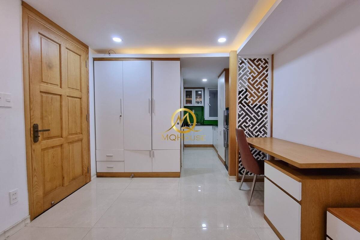 A modern kitchen with white cabinets, a wooden countertop, and a patterned wall.