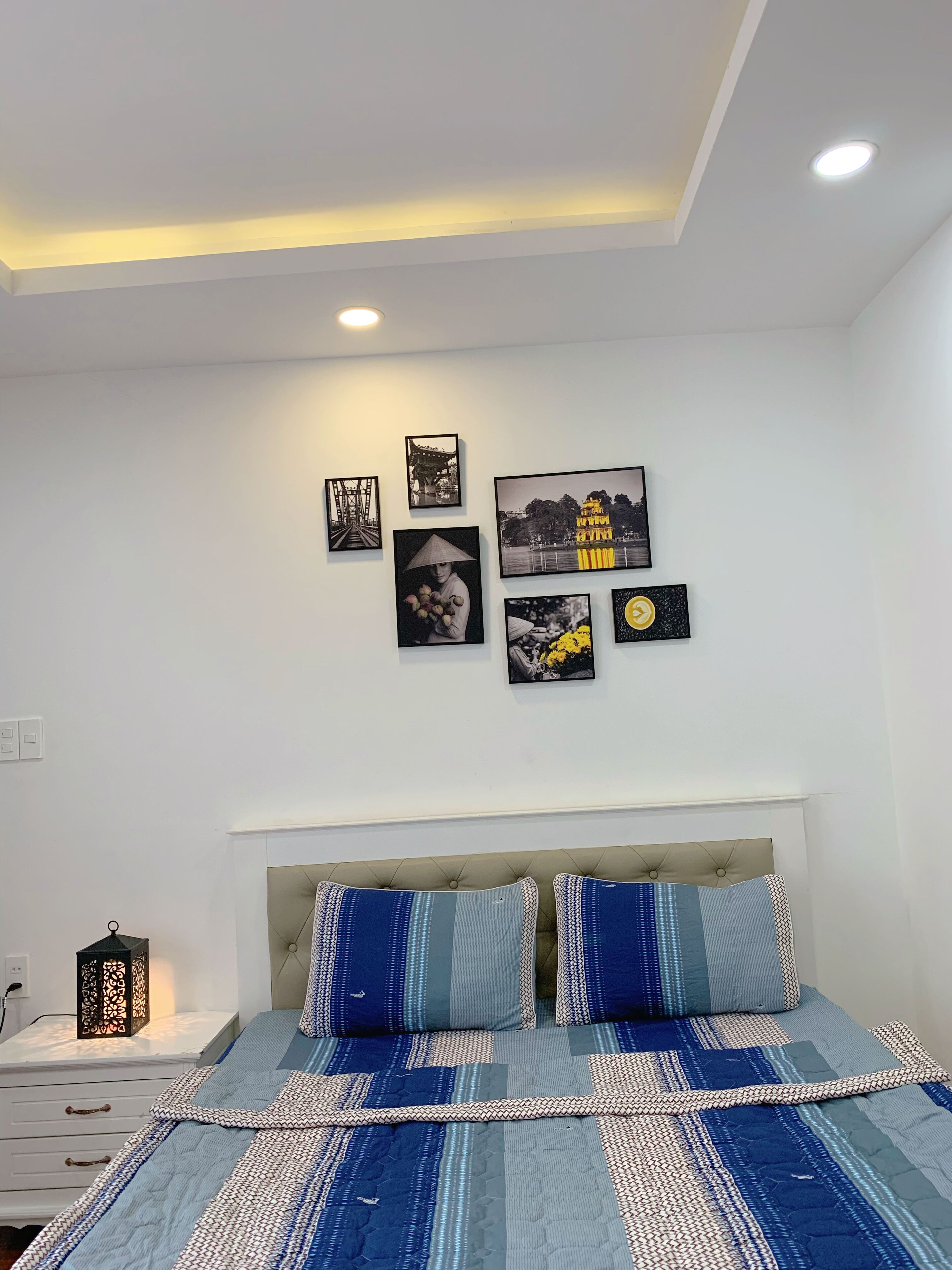 Un dormitorio con cama, mesita de noche y decoración en la pared.