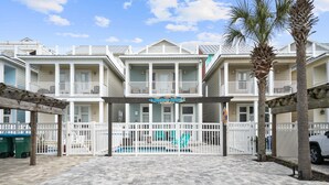 A beachfront hotel with a pool, white balconies, and palm trees. - Steps from the Beach Pet Friendly HUGE Discounts for Sept!!!! (Panama City)