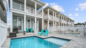 A swimming pool with a blue shark design, surrounded by a white fence, and a building with multiple balconies and outdoor seating. - Steps from the Beach Pet Friendly HUGE Discounts for Sept!!!! (Panama City)