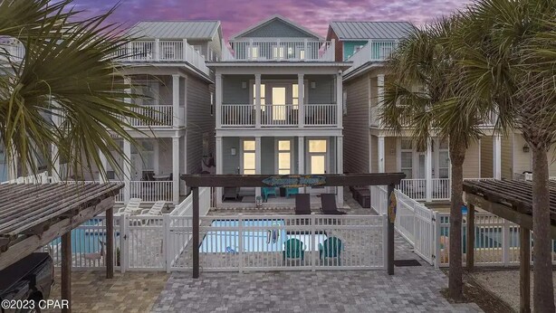 A beachfront property with multiple balconies, a pool, and palm trees. - Steps from the Beach Pet Friendly HUGE Discounts for Sept!!!! (Panama City)