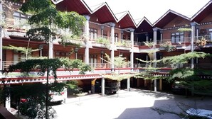 Un immeuble à plusieurs étages doté d’une cour intérieure, de balcons et d’une galerie couverte.