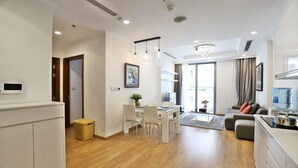 A modern apartment with a dining area, kitchen, and living room. - Bom Homestay Vinhomes Times City (Hanoi)