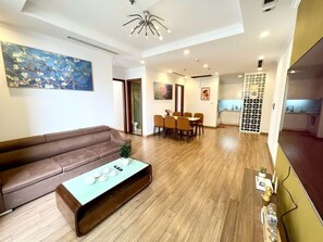 Luxury Apartment, 3 Bedrooms | Living area | 50-inch Smart TV with cable channels, TV - Bom Homestay Vinhomes Times City (Hanoi)