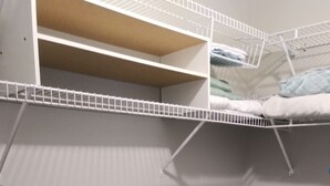 A walk-in closet with white shelving, a white dresser with blue handles, and a grey carpeted floor. - Sunset Serenity Relaxation Convenient attached apartment. (Dry Ridge)