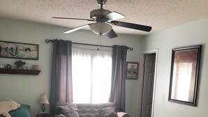 A bedroom with two beds, a ceiling fan, a window with curtains, a door, and a framed picture on the wall. - Sunset Serenity Relaxation Convenient attached apartment. (Dry Ridge)