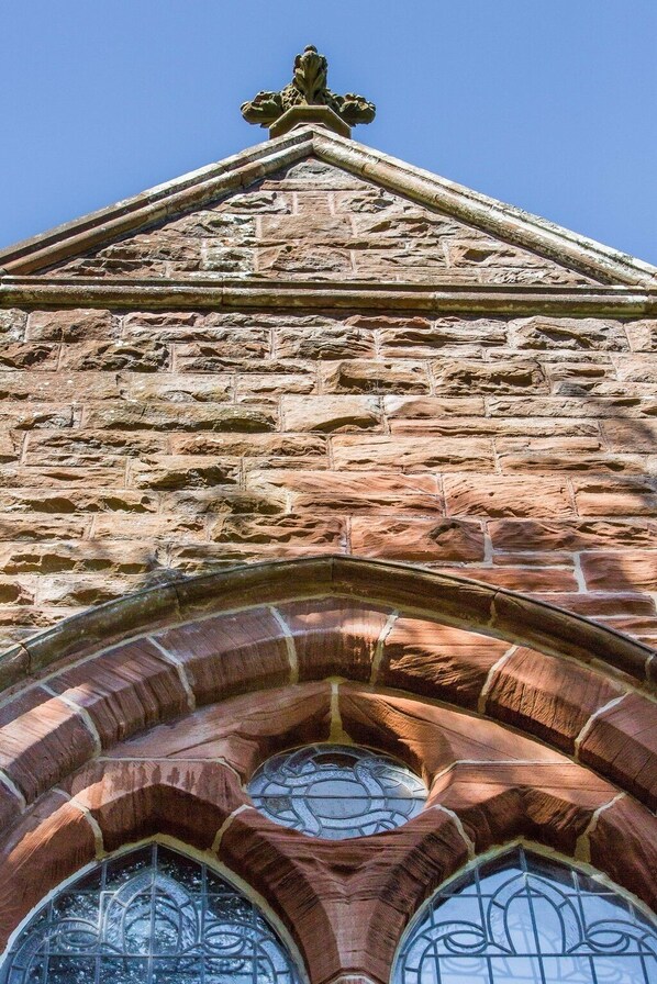 A stone building with a triangular pediment and arched windows. - Eastkirk (Isle of Arran)