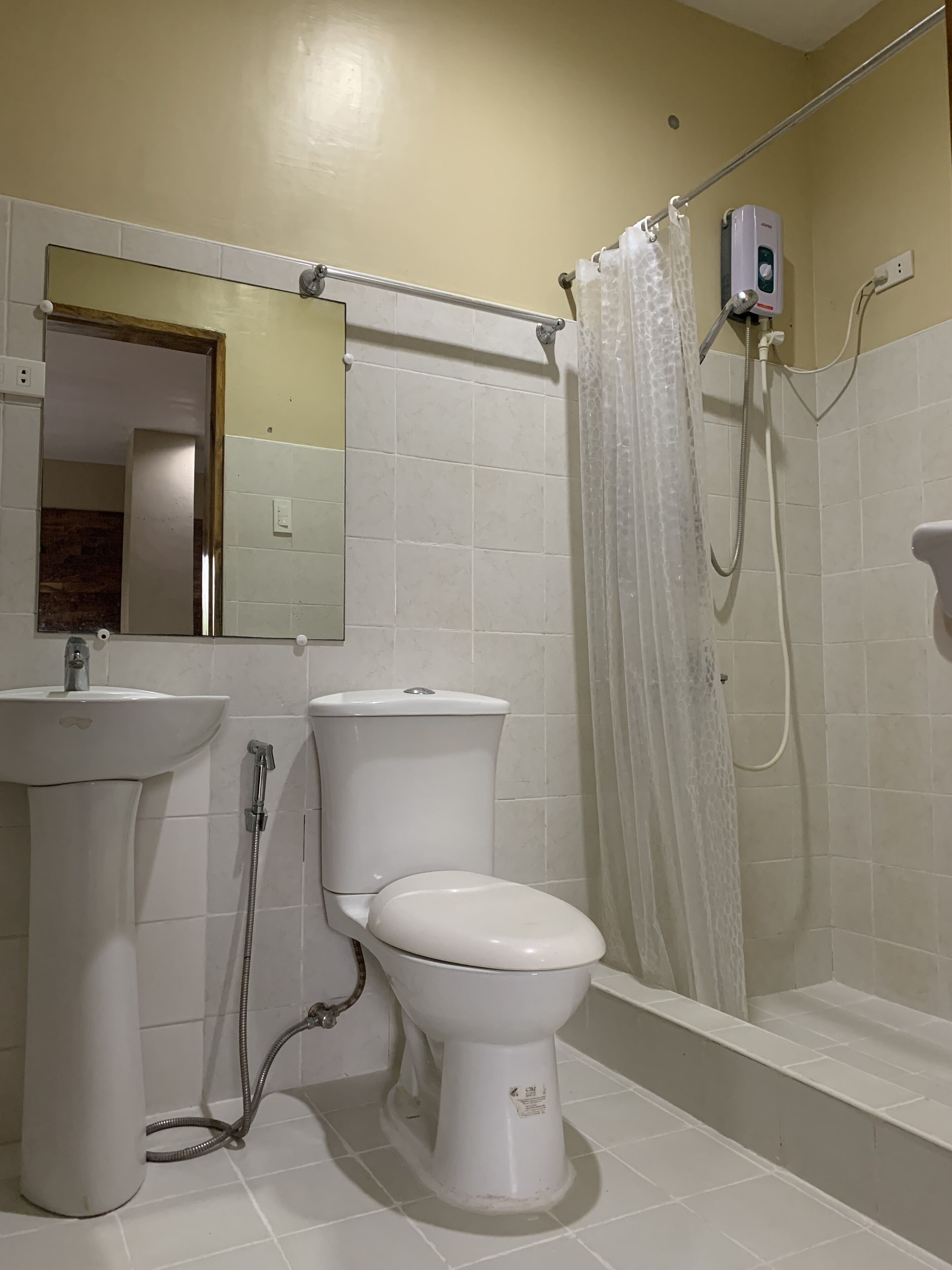 Une salle de bain avec des toilettes, un lavabo et une douche.