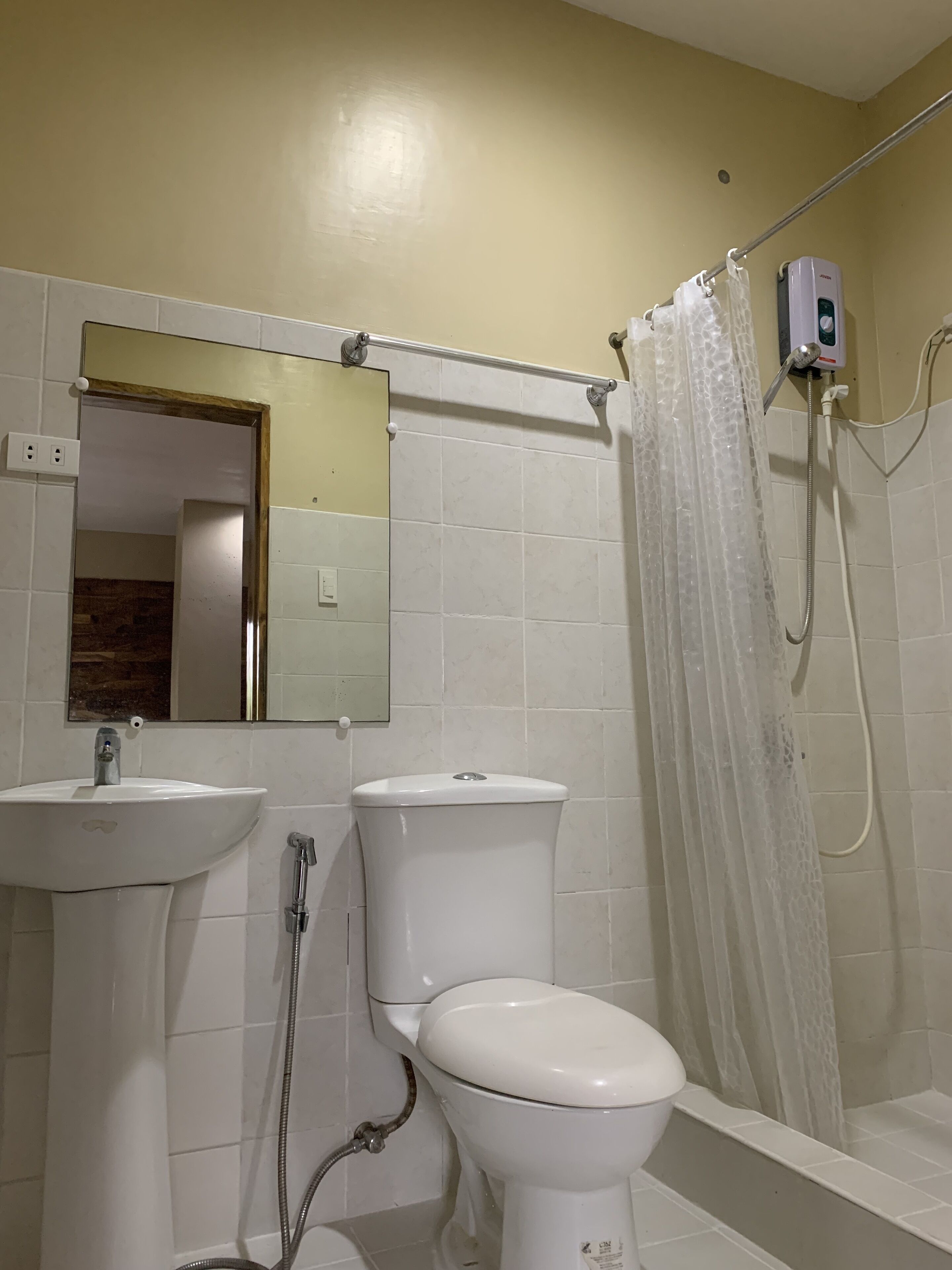 Une salle de bain avec un lavabo, des toilettes et une douche.
