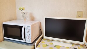 A microwave and a Sharp monitor on a table with a lemon-patterned tablecloth. - Petit Asahi 201 (Kobe)