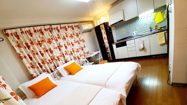 A hotel room with two beds, a kitchenette, and a bathroom. - Petit Asahi 201 (Kobe)