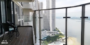 A balcony with a view of a river and high-rise buildings. - Picturesque View Suites (Johor Bahru)
