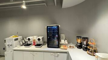 Cozinha moderna com máquina de café, geladeira e diversos recipientes de comida.