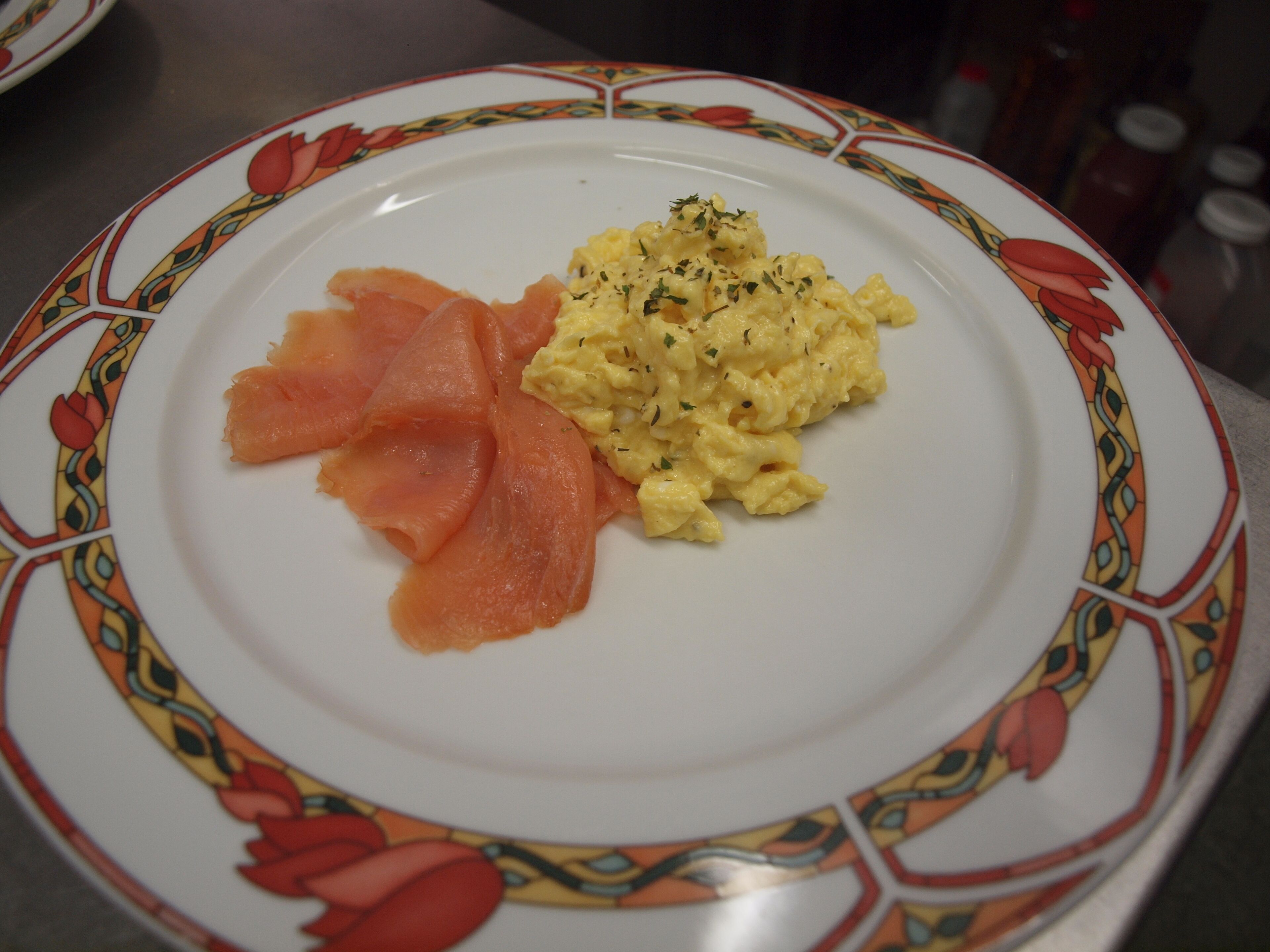 A plate with smoked salmon and scrambled eggs.