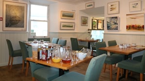 A dining area with tables set for breakfast, featuring various condiments and beverages. - Herriot's in Hawes (Hawes)
