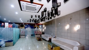 A modern lobby with a white sofa, a glass coffee table, and a decorative plant. - Hotel darshan naroda (Ahmedabad)