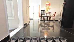 A hallway with a dining area, including a table and chairs, and a refrigerator. - Jerry Blossom - Hostel (Seoul)