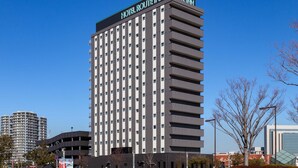 Un grand immeuble d’hôtel sur lequel on peut lire, en haut, l’inscription « HOTEL ROUTE INN ROUTE INN ».