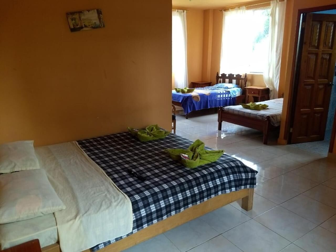 Een kamer met een bed, een stoel, een tafel en een deur.