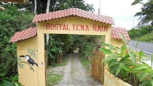 A hostel entrance with a tiled roof and a sign that reads "HOSTAL TENA NAIU". - Hostal Tena Ñaui (Tena)