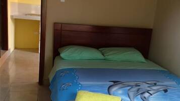 Un dormitorio con una cama, cabecera de madera y una toalla amarilla sobre la cama.