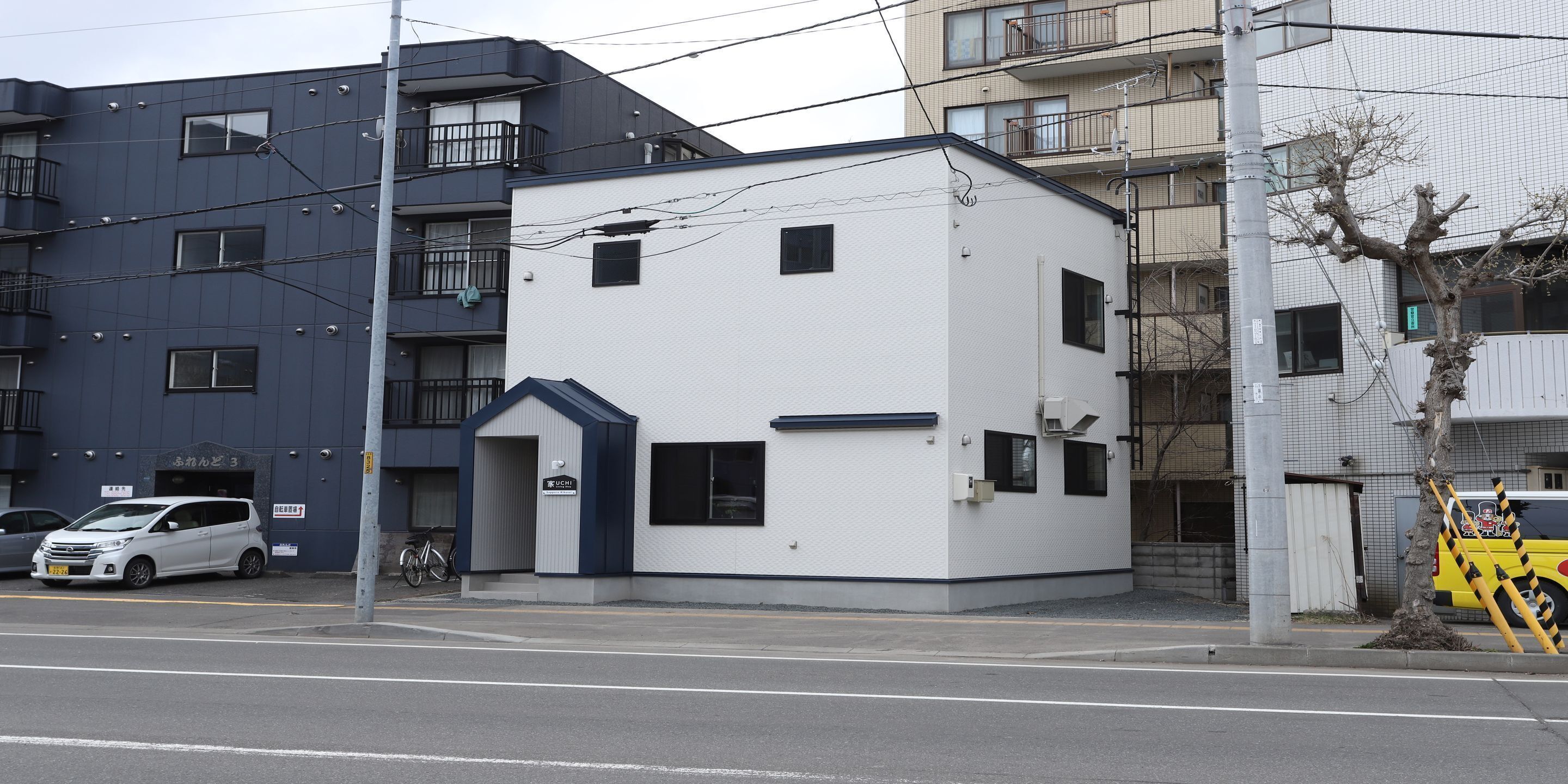 A small, white building with a blue roof and a sign that reads "UCHI".