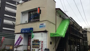 A building with a vending machine, a sign for 'Mitchie', and a green awning. - Michio's House (Ebina)