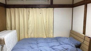 A room with a bed, a window with curtains, and an air conditioning unit. - Michio's House (Ebina)
