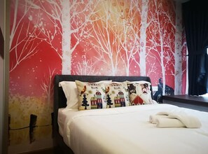 A hotel room with a bed, white bedding, and a wall mural depicting trees and houses. - Pool View Suites (Johor Bahru)
