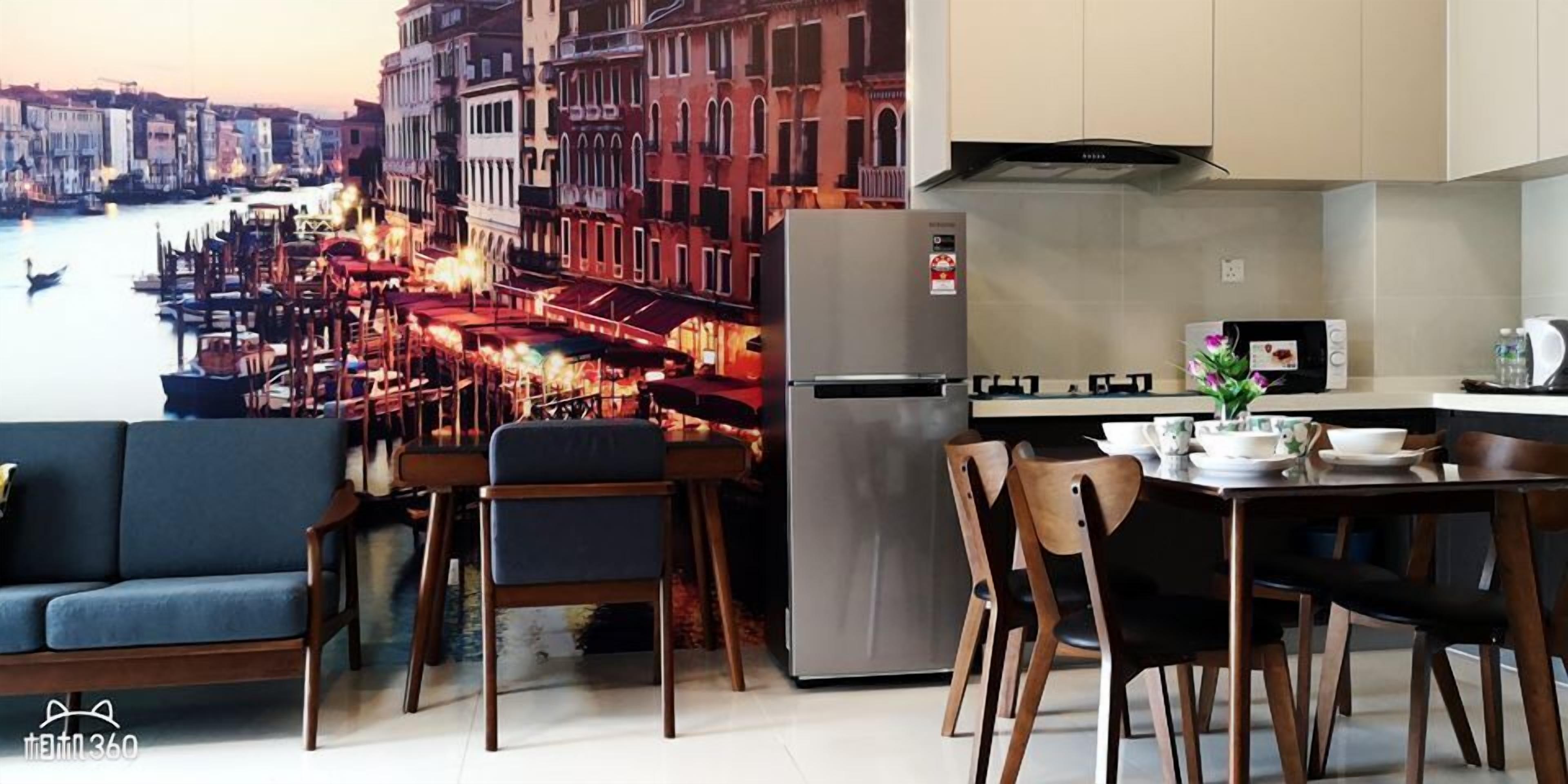 A modern kitchen with a stainless steel refrigerator, a dining table with chairs, and a view of a cityscape with buildings and a river.